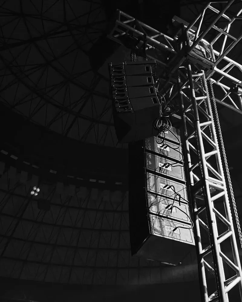 Line array pendurado na treliça de um palco, visto de baixo