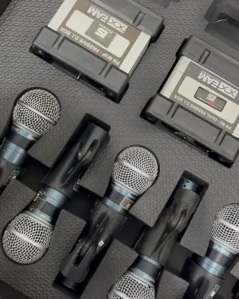 Microfones Shure de mão guardados no case com os transmissores sem fio