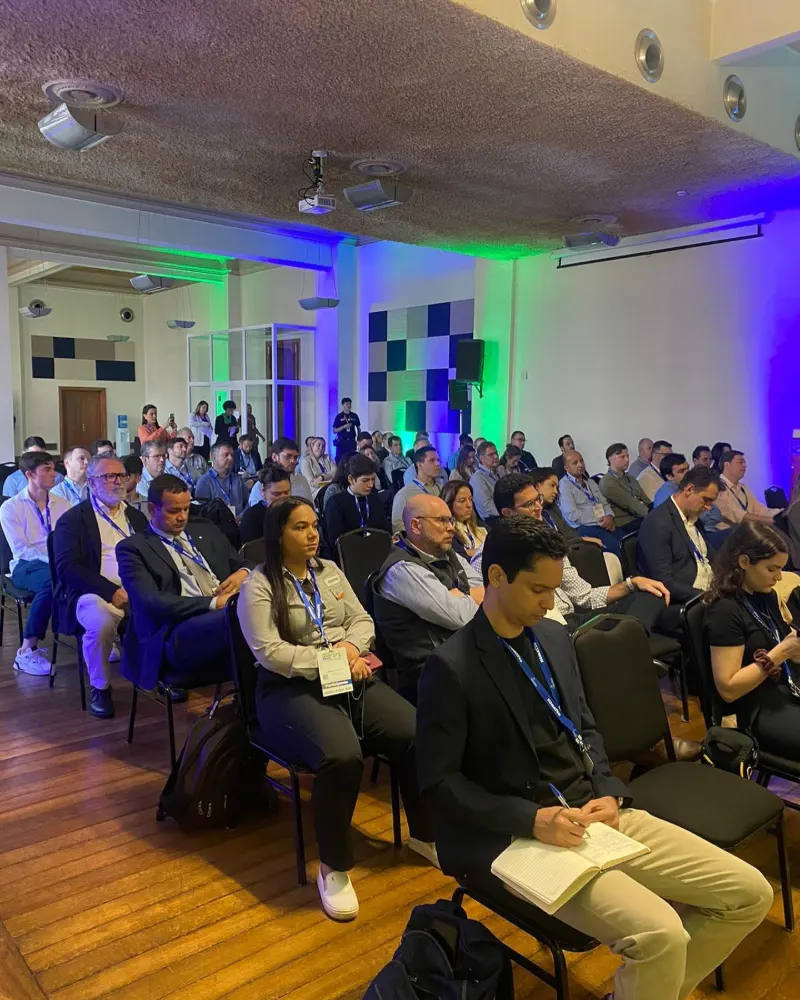Plateia sentada assistindo a uma palestra em evento corporativo