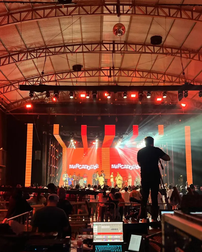 Show visto da técnica de som, com o palco iluminado em vermelho e laranja