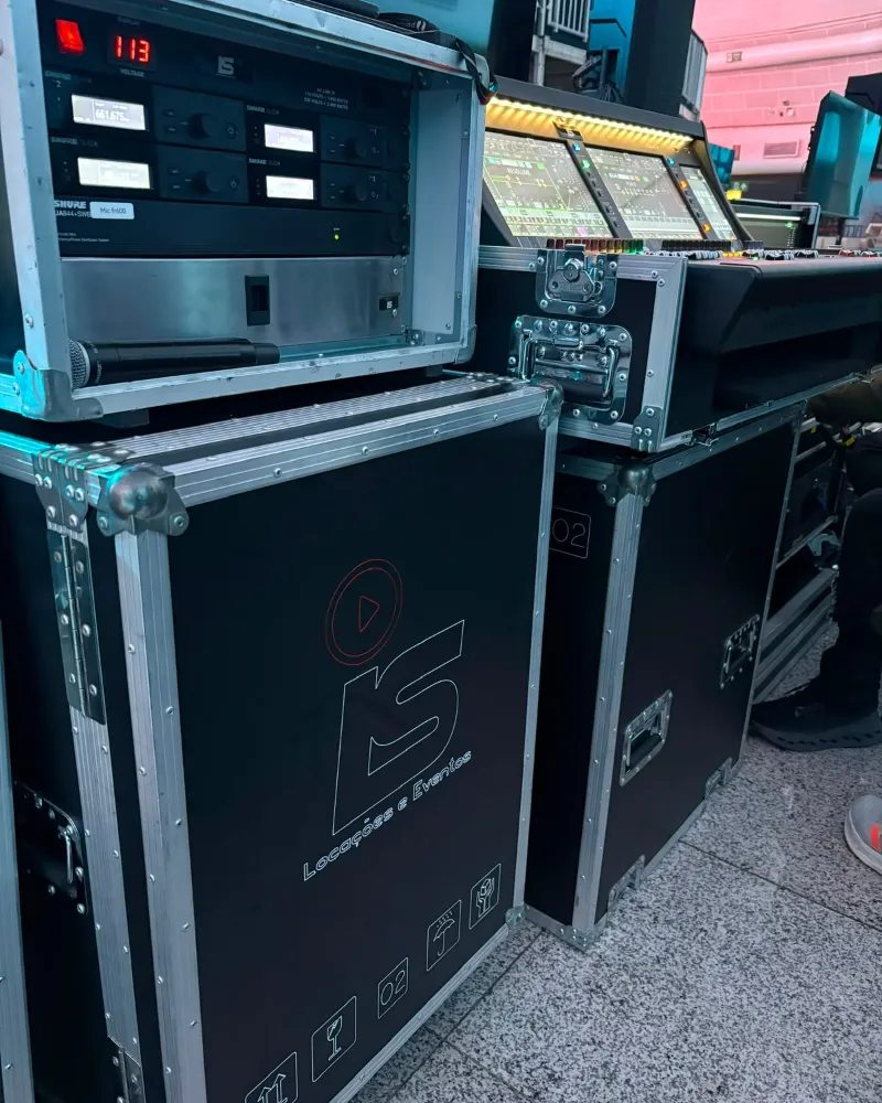 Cases da IS Locações com o rack de receptores sem fio Shure SLX-D ao lado da mesa de som